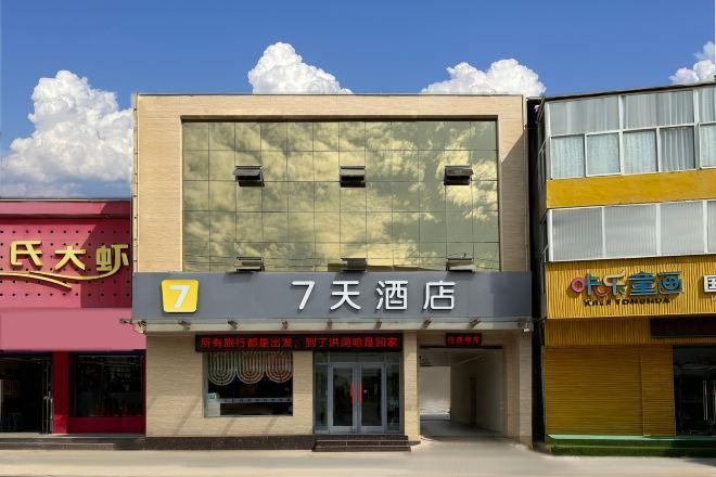 Um hotel com um grande letreiro que diz '7天酒店' e o número '7' na fachada.