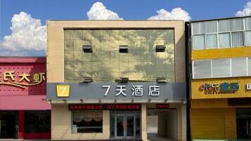 A hotel with a large sign reading '7天酒店' and a number '7' on the facade.