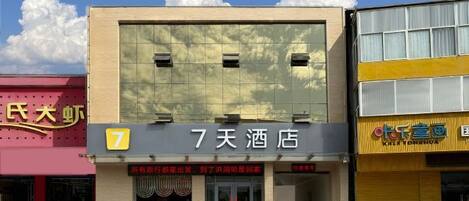 A hotel with a large sign reading '7天酒店' and a number '7' on the facade.