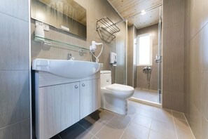Un baño moderno con lavamanos, inodoro y ducha.