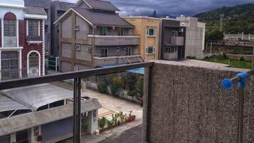 Un edificio residencial de varios pisos, con balcones y vistas a un área verde con plantas.
