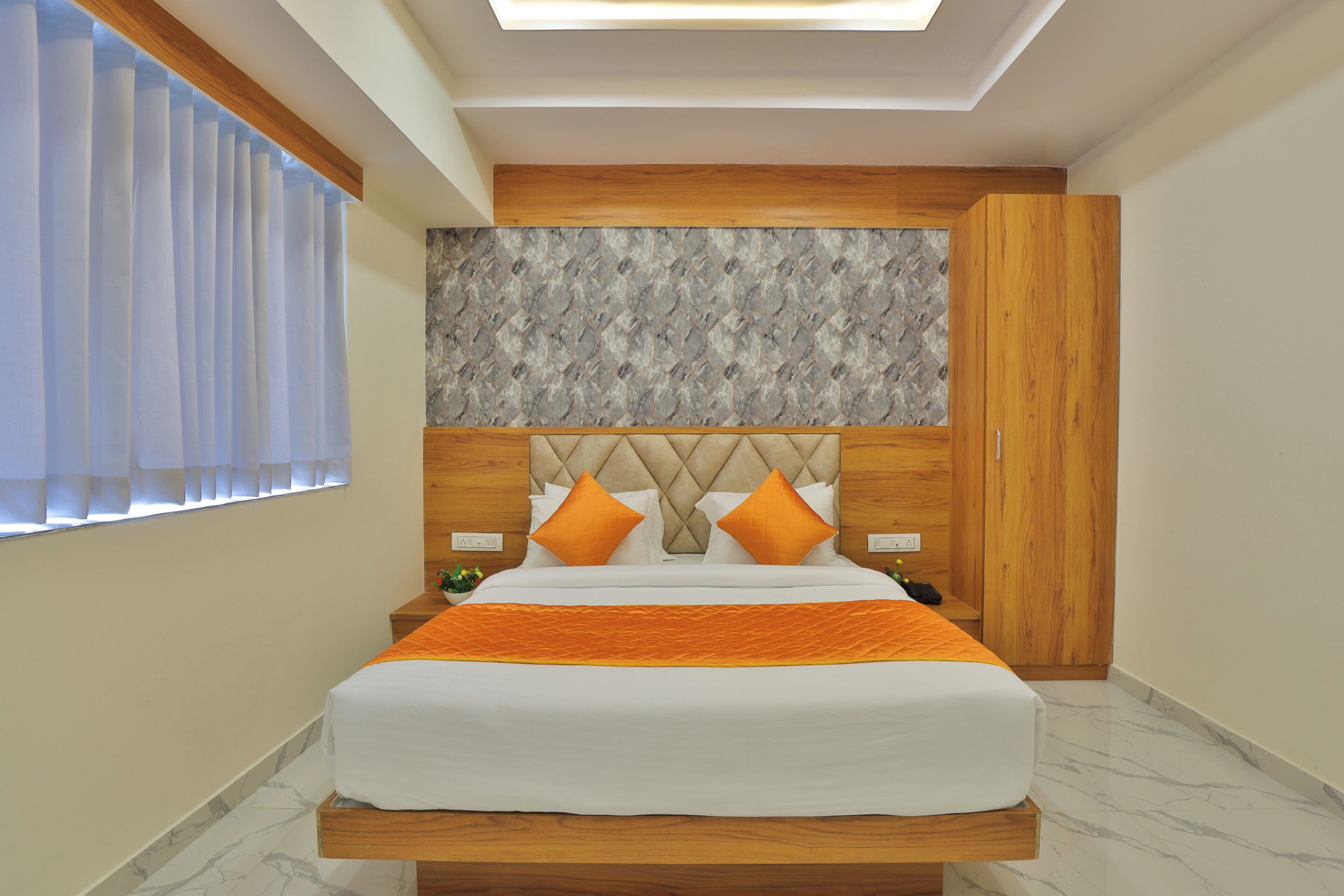 A bedroom with a bed, wooden headboard, and a nightstand.
