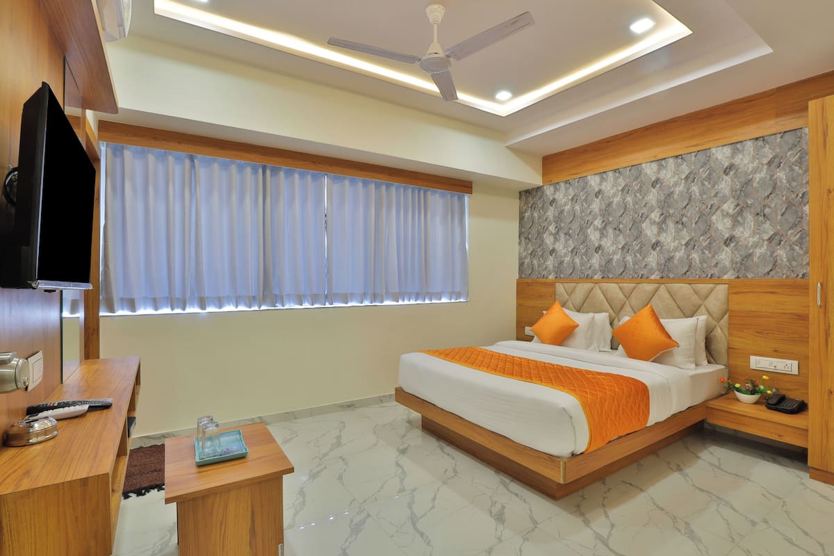 A modern bedroom with a bed, bedside table, and a TV on a stand.