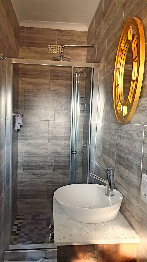 Chuveiro, toalhas de banho, sabonete, papel higiênico