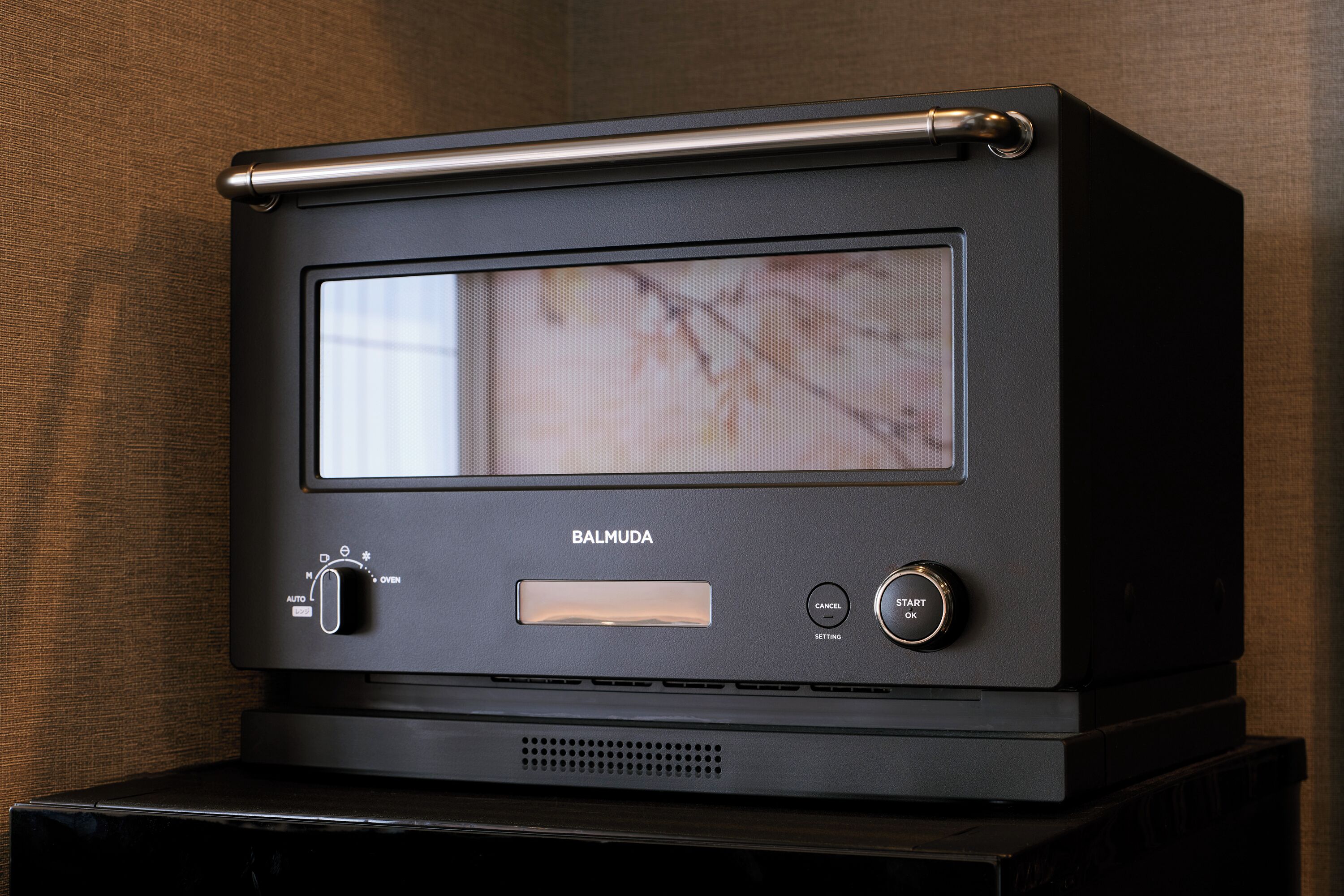 Een zwarte Barmuda oven met een bedieningspaneel, een kijkraam en een metalen handgreep.