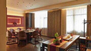 Un comedor moderno de hotel con una larga mesa, sillas y una decoración central.
