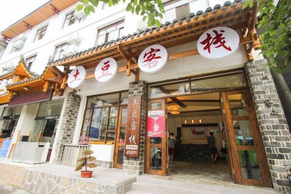 A traditional building with a tiled roof, wooden beams, and a stone facade. - Zhangjiajie Potato Inn Baofeng Branch (Zhangjiajie)