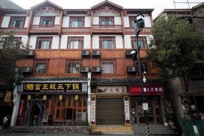 A traditional multi-story building with commercial spaces on the ground floor, including a closed shop and a restaurant. - Zhangjiajie Potato Inn Baofeng Branch (Zhangjiajie)