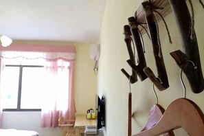 A room with a bed, a desk with a chair, a window with curtains, and wall-mounted items. - Zhangjiajie Potato Inn Baofeng Branch (Zhangjiajie)