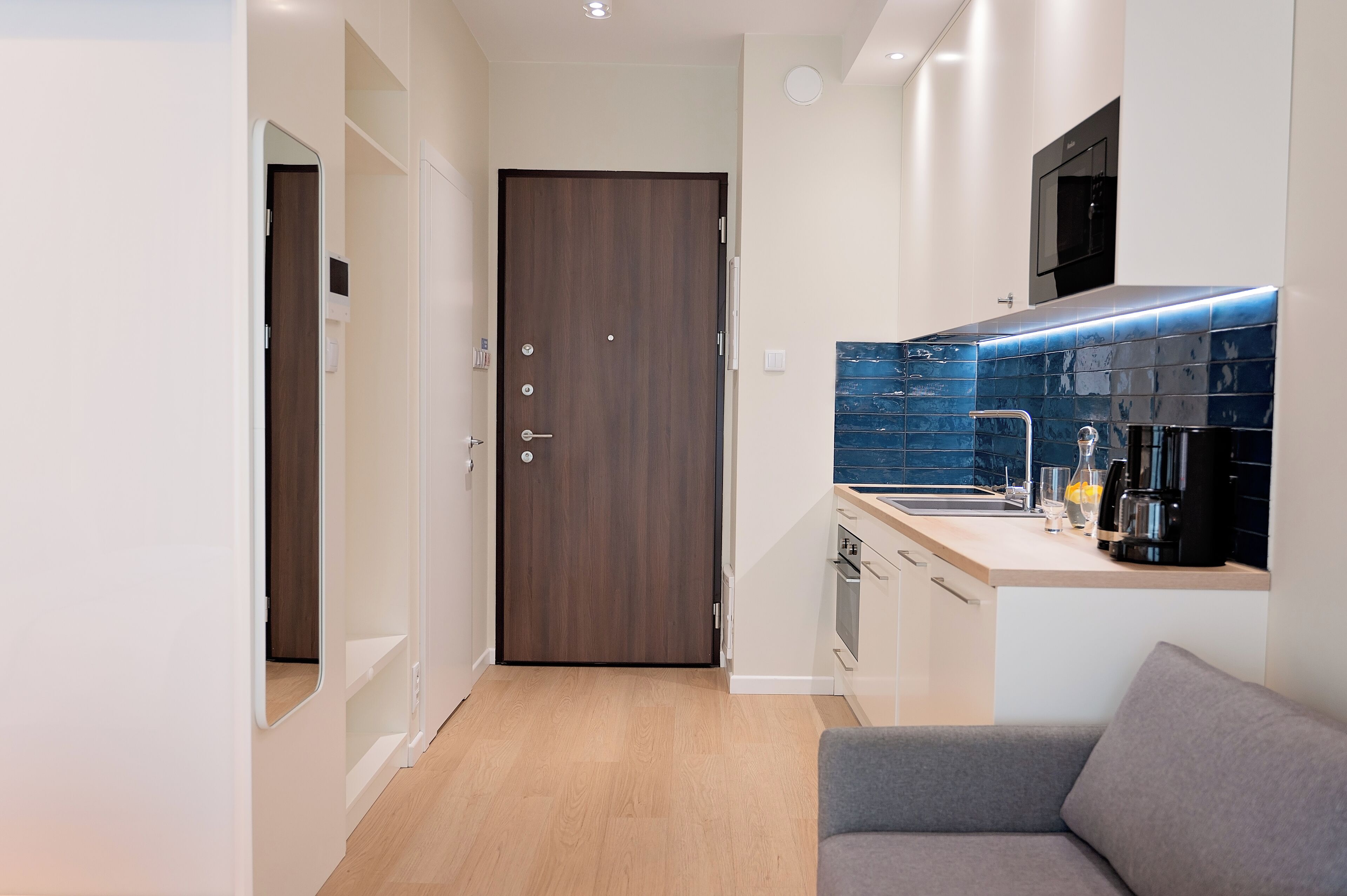 A compact kitchen with a built-in oven, a coffee maker, and a microwave.