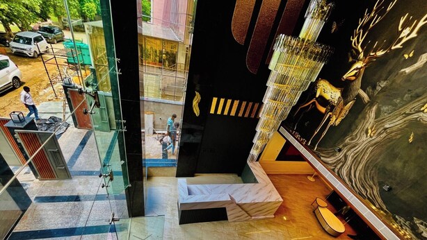A modern hotel lobby with a marble floor, a glass partition, and a large mural of a deer.