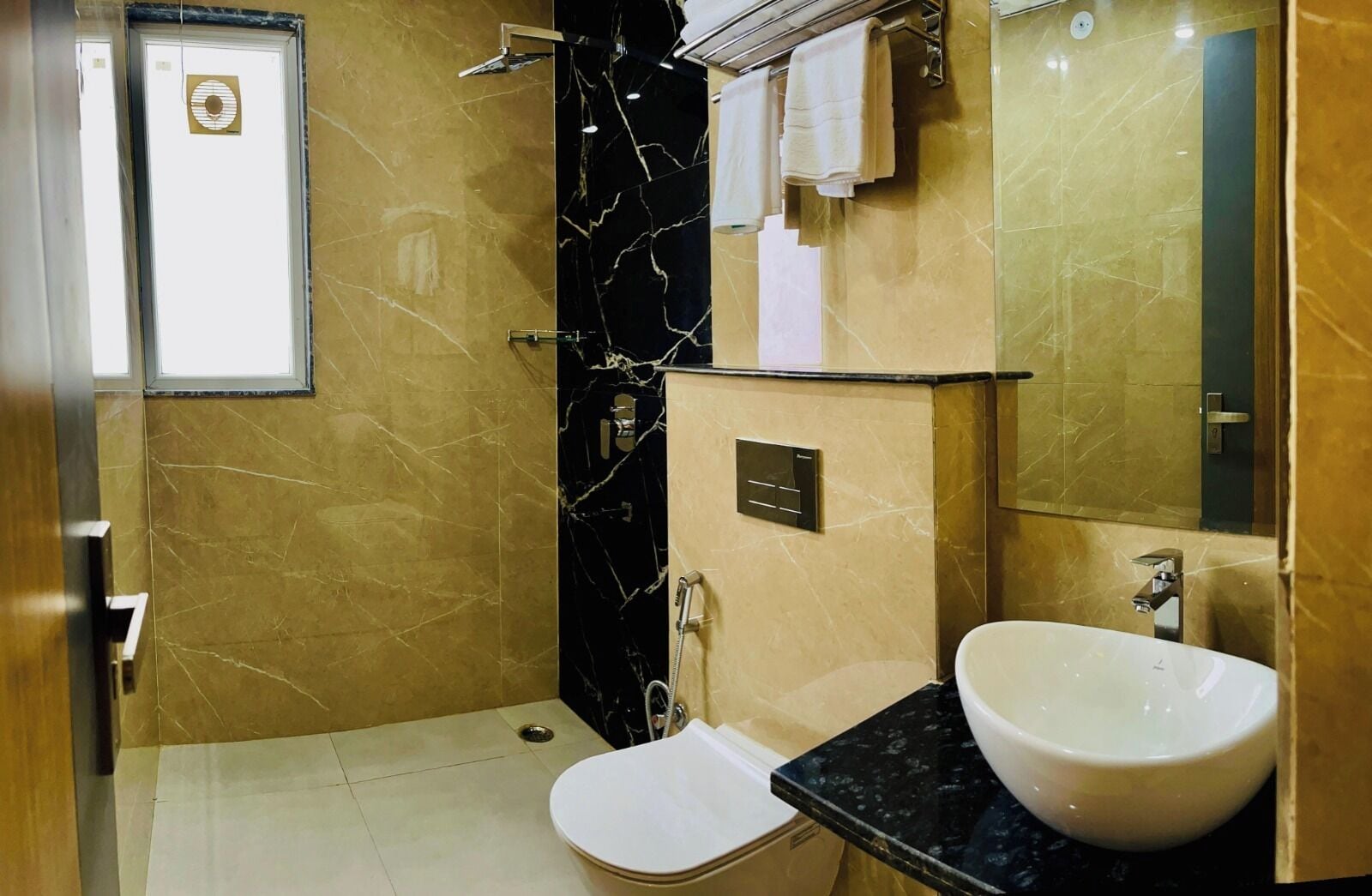 A bathroom with a toilet, sink, and mirror.