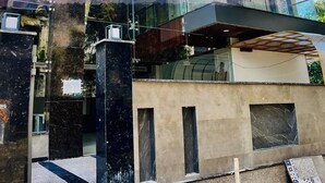A modern building with multiple floors, large glass windows, and a reflective facade.