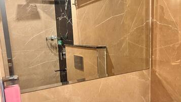 A bathroom with a large mirror, a white sink, and a towel rack.