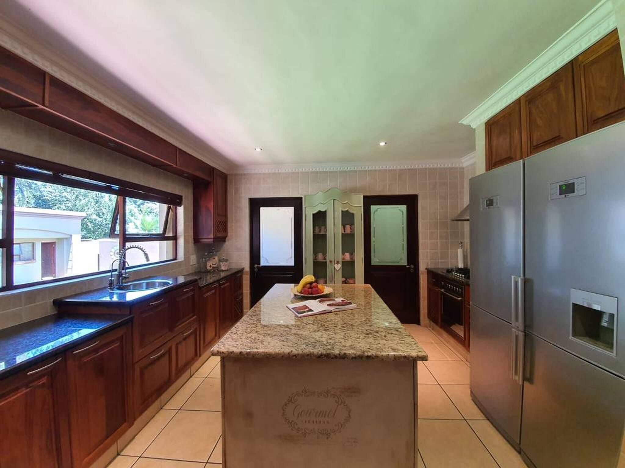 A modern kitchen with granite countertops, stainless steel appliances, and wooden cabinets.