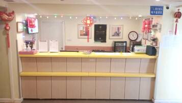 A reception desk with a counter, a clock, and a framed certificate on the wall.