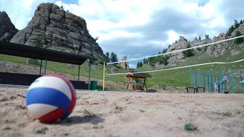 Un terrain de volley-ball avec un filet, un banc et un abri.