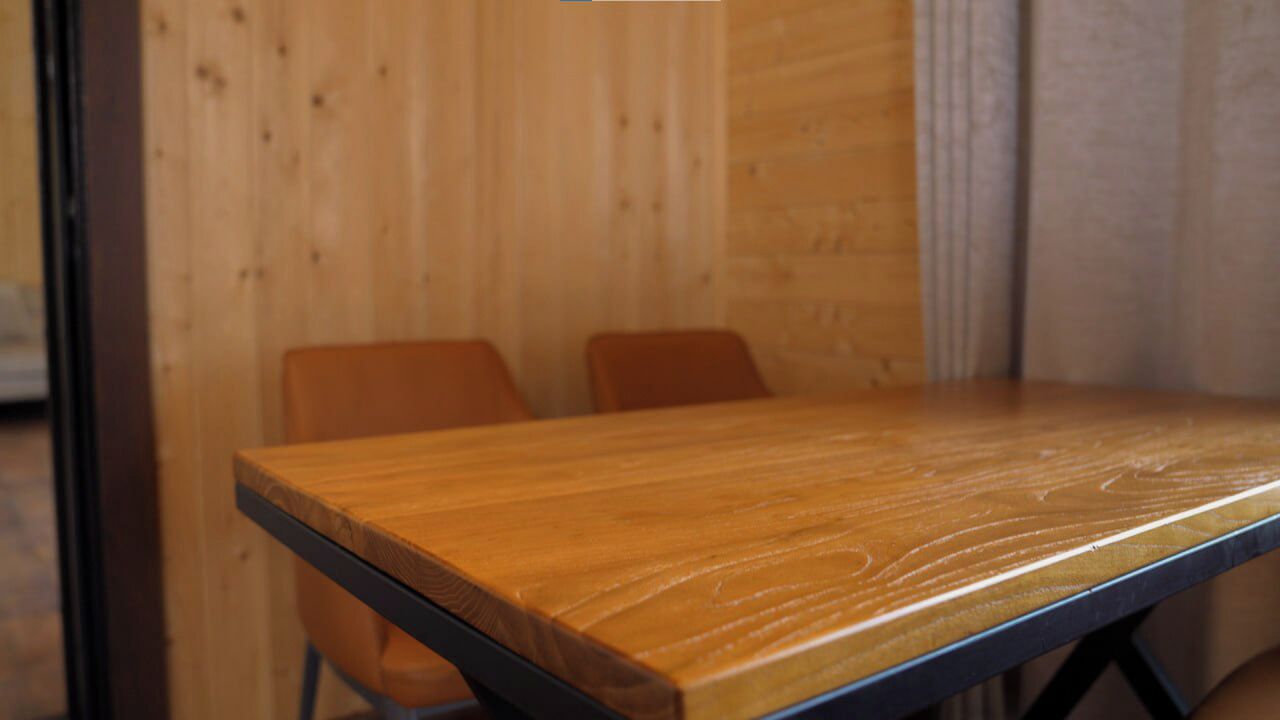 Ein Holztisch mit zwei Stühlen in einem Raum mit Holzwänden.