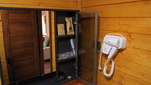 A wooden room with a sauna, a glass door, and a hairdryer on the wall. - Energy Hills Resort (Ulaanbaatar)