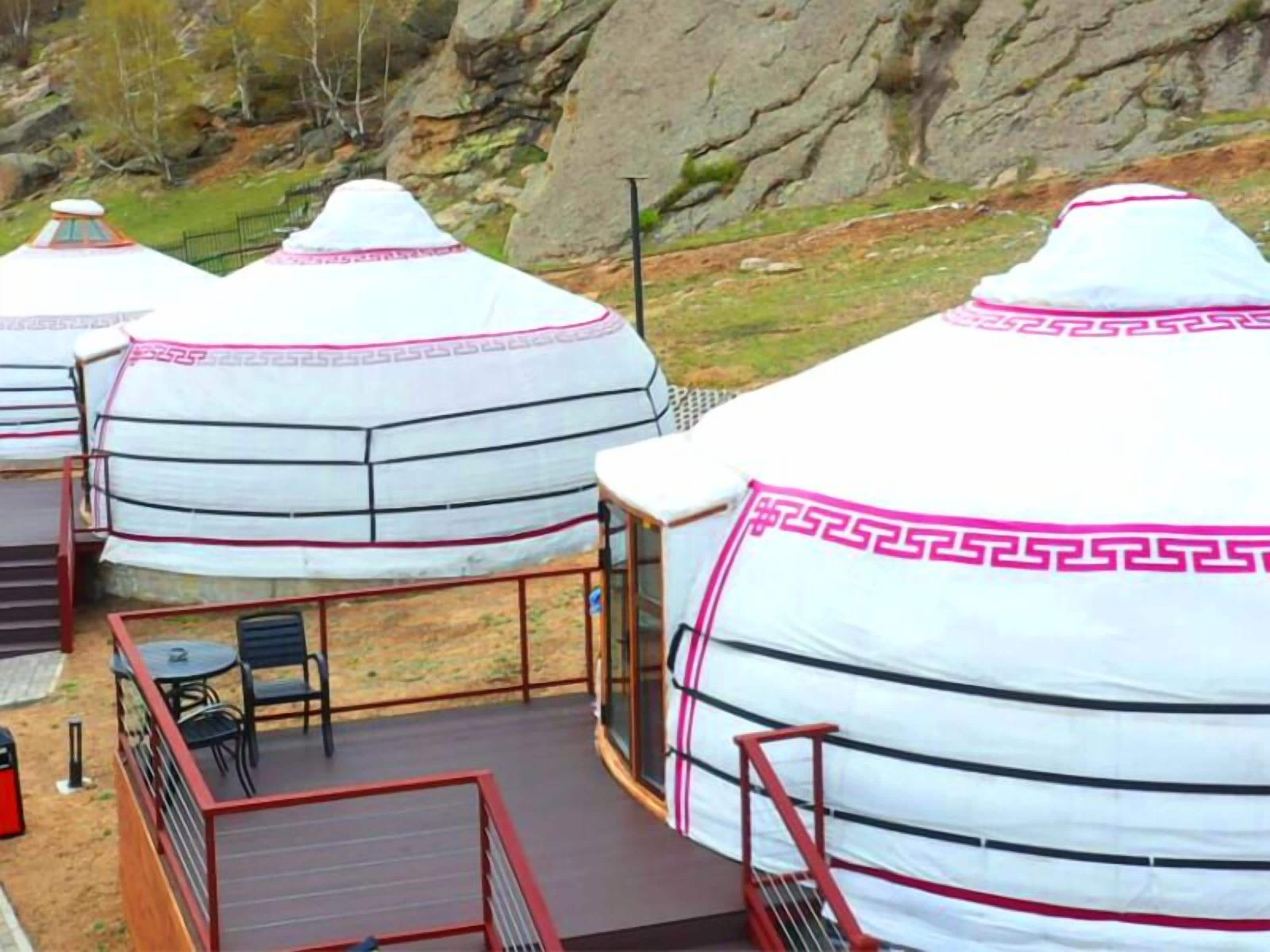 En yurt med en træterrasse og et bord.