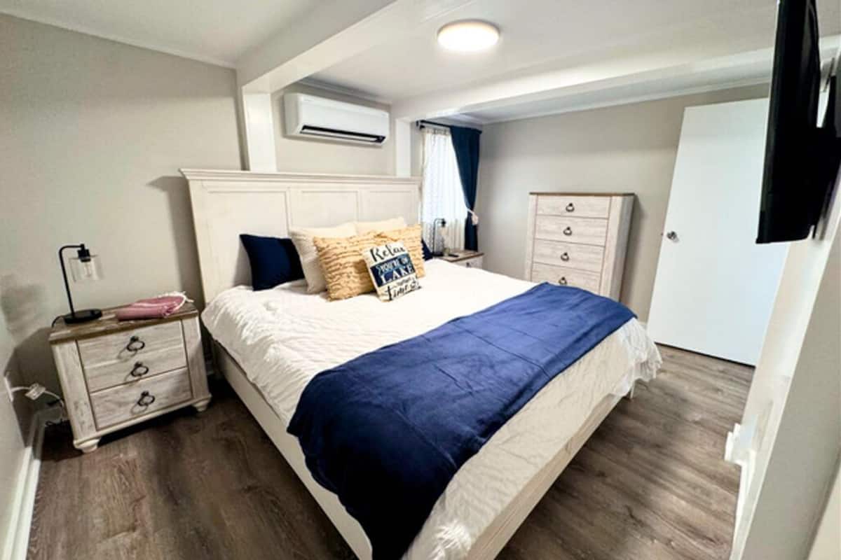 Un dormitorio con cama, mesita de noche, cómoda y televisor.