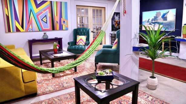 Ein Wohnzimmer mit einer Hängematte, zwei grünen Sesseln, einem gelben Sofa, einem Couchtisch und einem Fernseher auf einem Schrank.