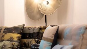 A modern living room with a sofa and decorative wall lamps. - Maxim Suites by Elias Holl (Augsburg)