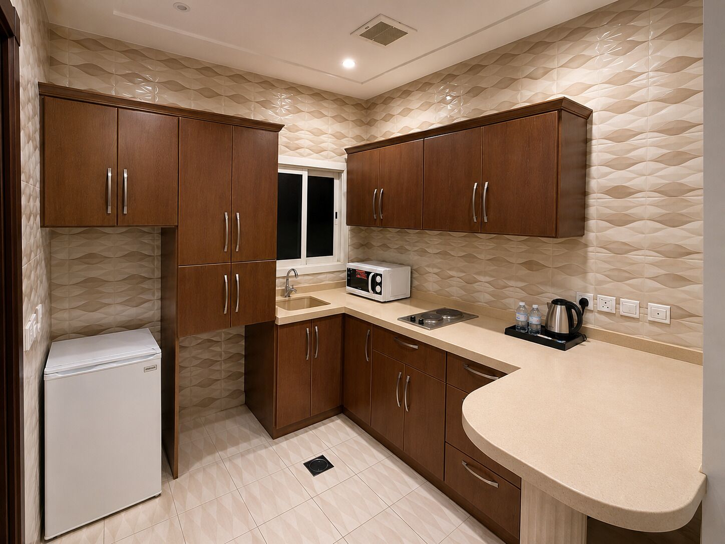 A compact kitchen with wooden cabinets, a built-in microwave, and a sink.
