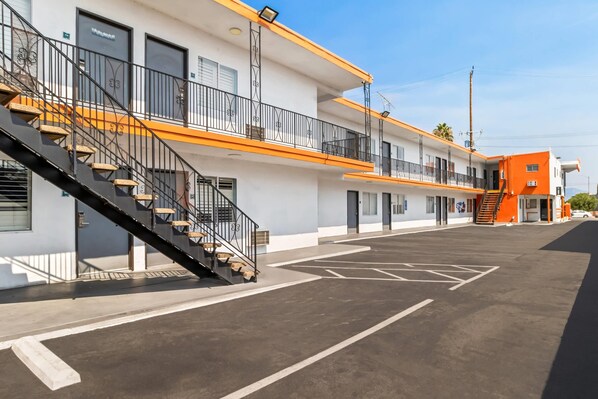 Un immeuble à plusieurs étages avec un parking situé à l’avant.