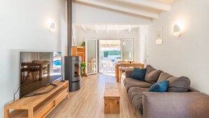 Uma sala de estar moderna com TV, sofá, mesa de centro de madeira e lareira.