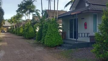 A residential area with a house featuring a tiled roof, a front porch, and a fire extinguisher mounted on the wall.