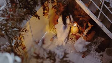 Experience a tranquil retreat with a cozy seating area, candlelit ambiance, and a warm atmosphere.