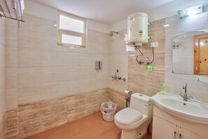 A bathroom with a toilet, sink, shower, and a window. - Hotel Nirosha Manali (Manali)