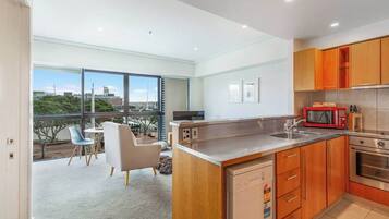 A modern kitchen with wooden cabinets, a stainless steel sink, and a built-in oven.