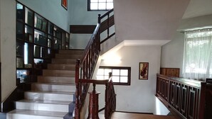 A spacious interior with a grand staircase, a large window, and a view of the outside. - Hotel Dew Pond  (Gangtok)