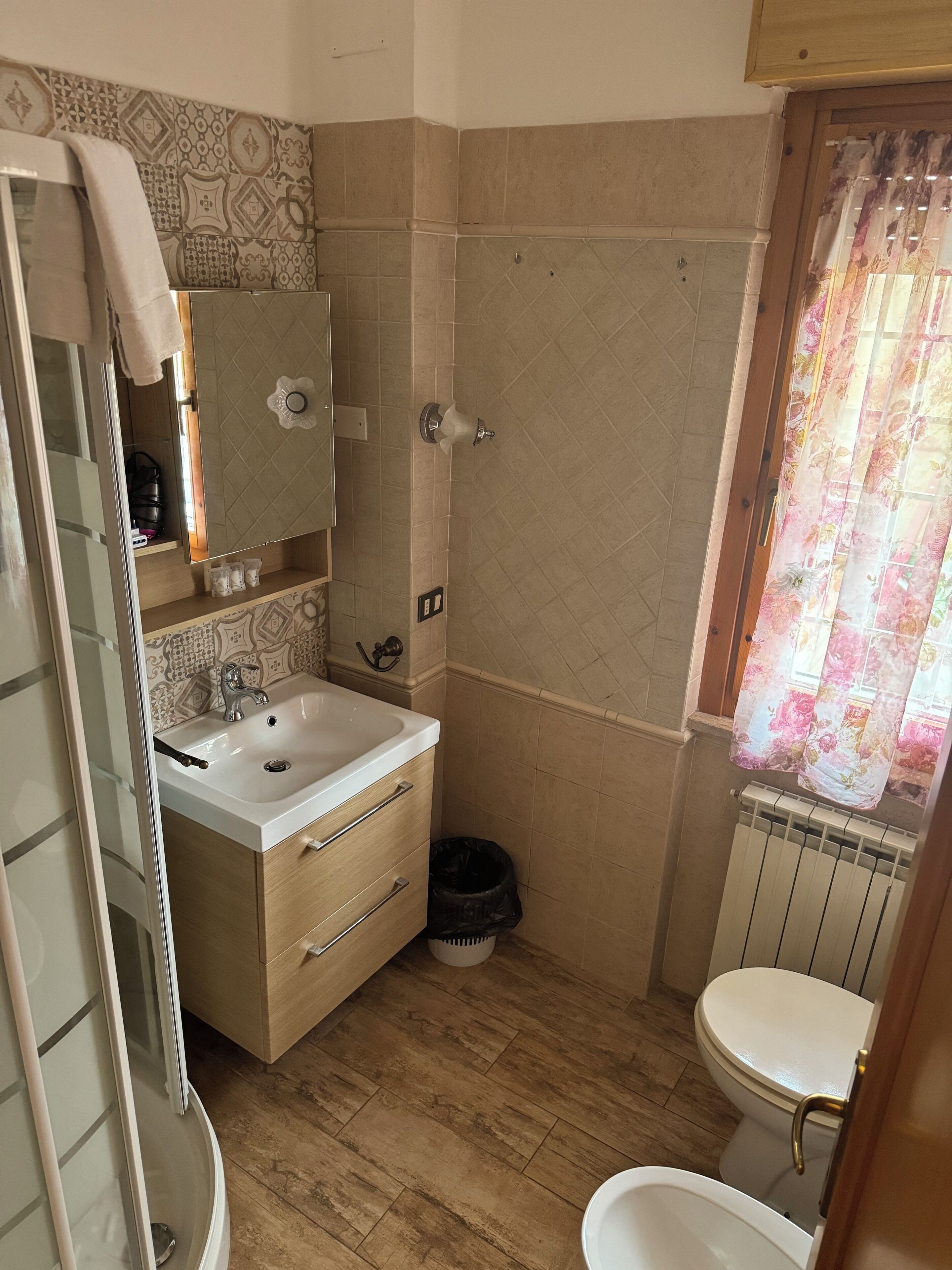 Un baño con lavamanos, espejo y retrete.