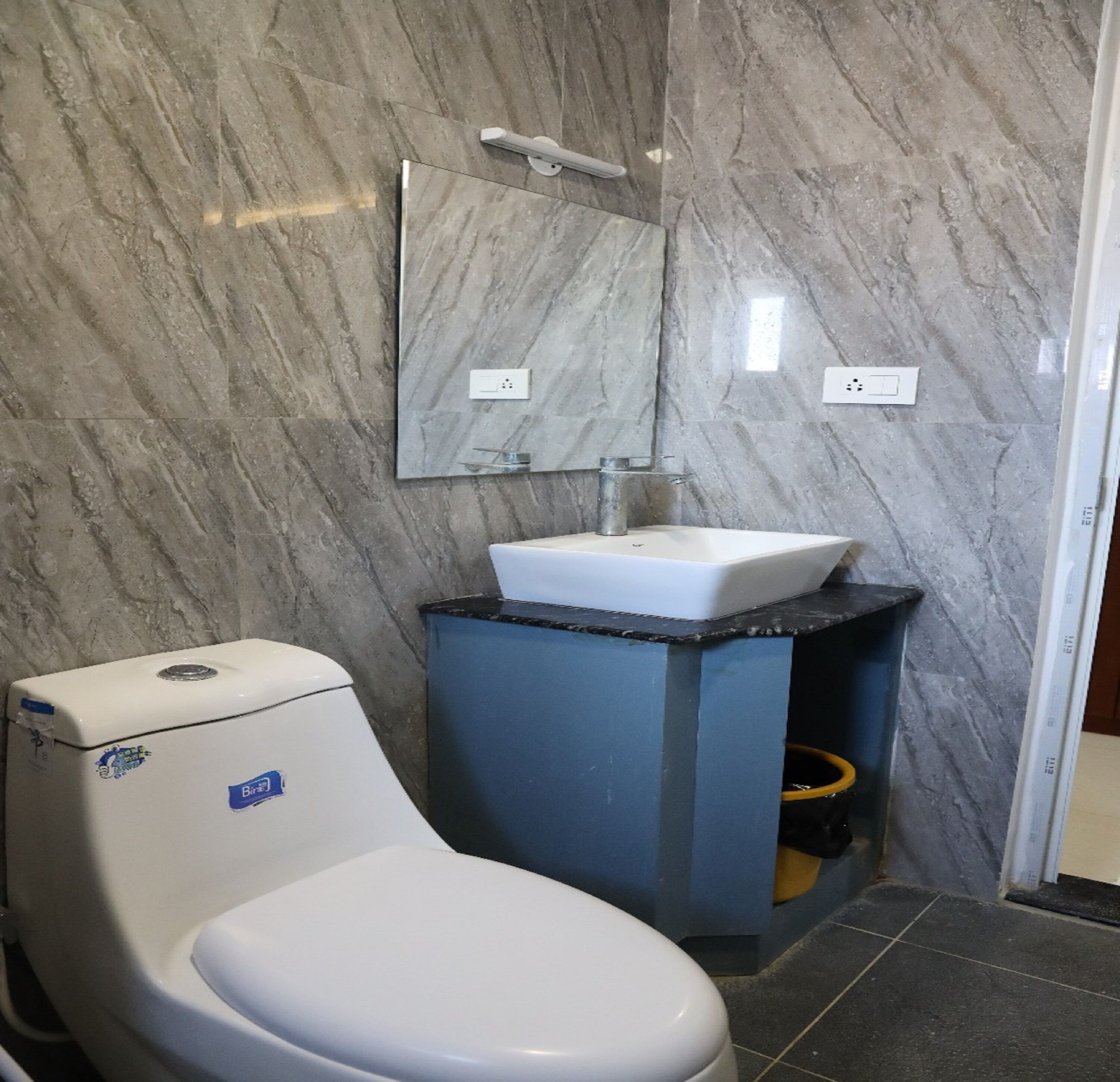 Ein Badezimmer mit Toilette, Waschbecken und Spiegel.