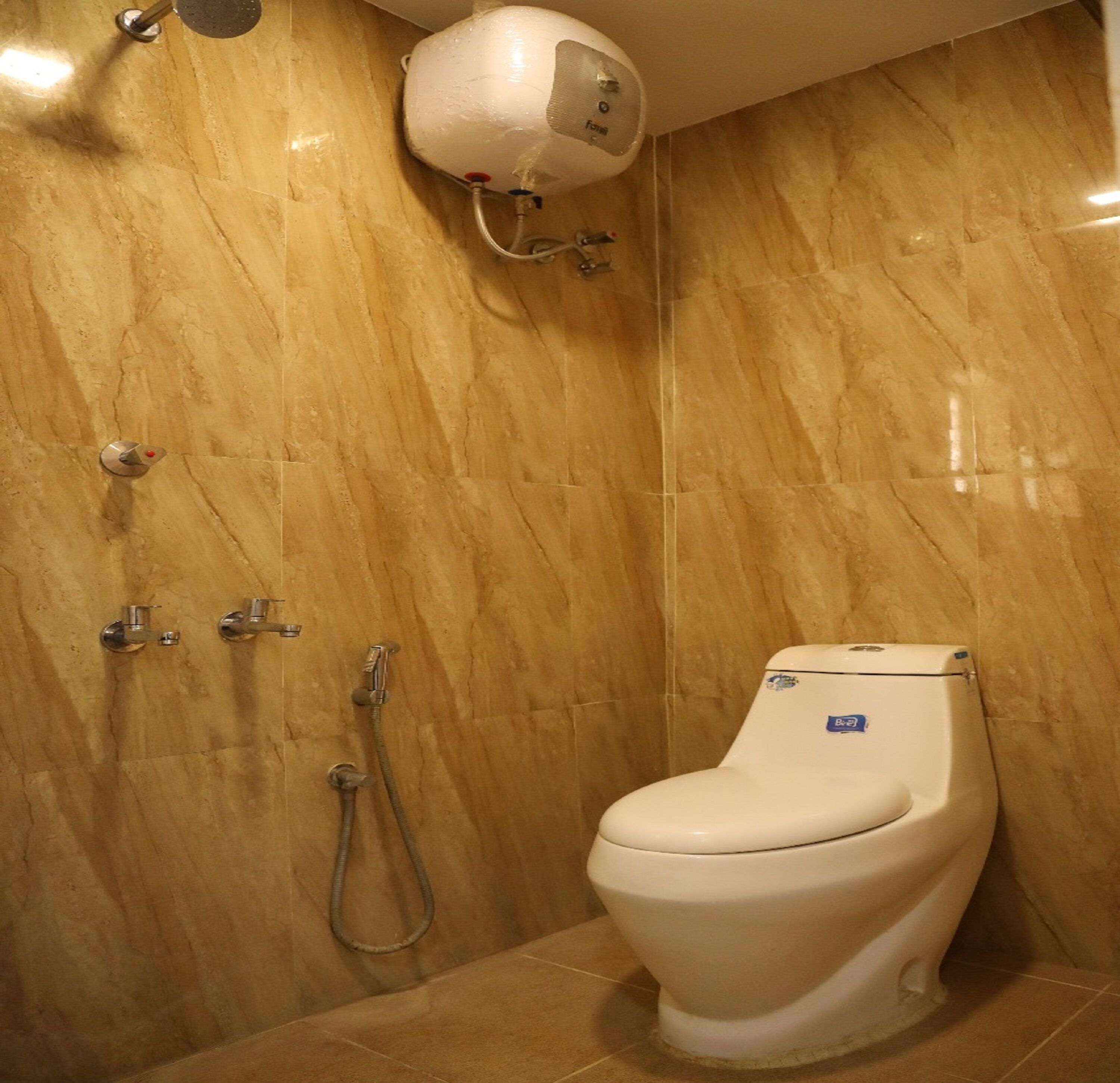 A bathroom with a toilet, a shower, and a wall-mounted water heater.