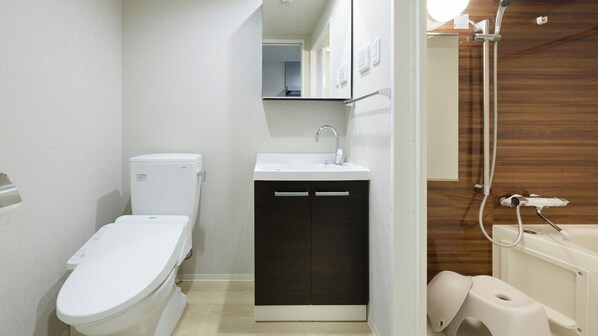 A modern bathroom with a toilet, sink, and shower.