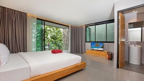 A modern bedroom with a large bed, a television, a wooden cabinet, and a bathroom with a sink. - Designer 4BR Pool Villa Gentle Breeze (Kamala)