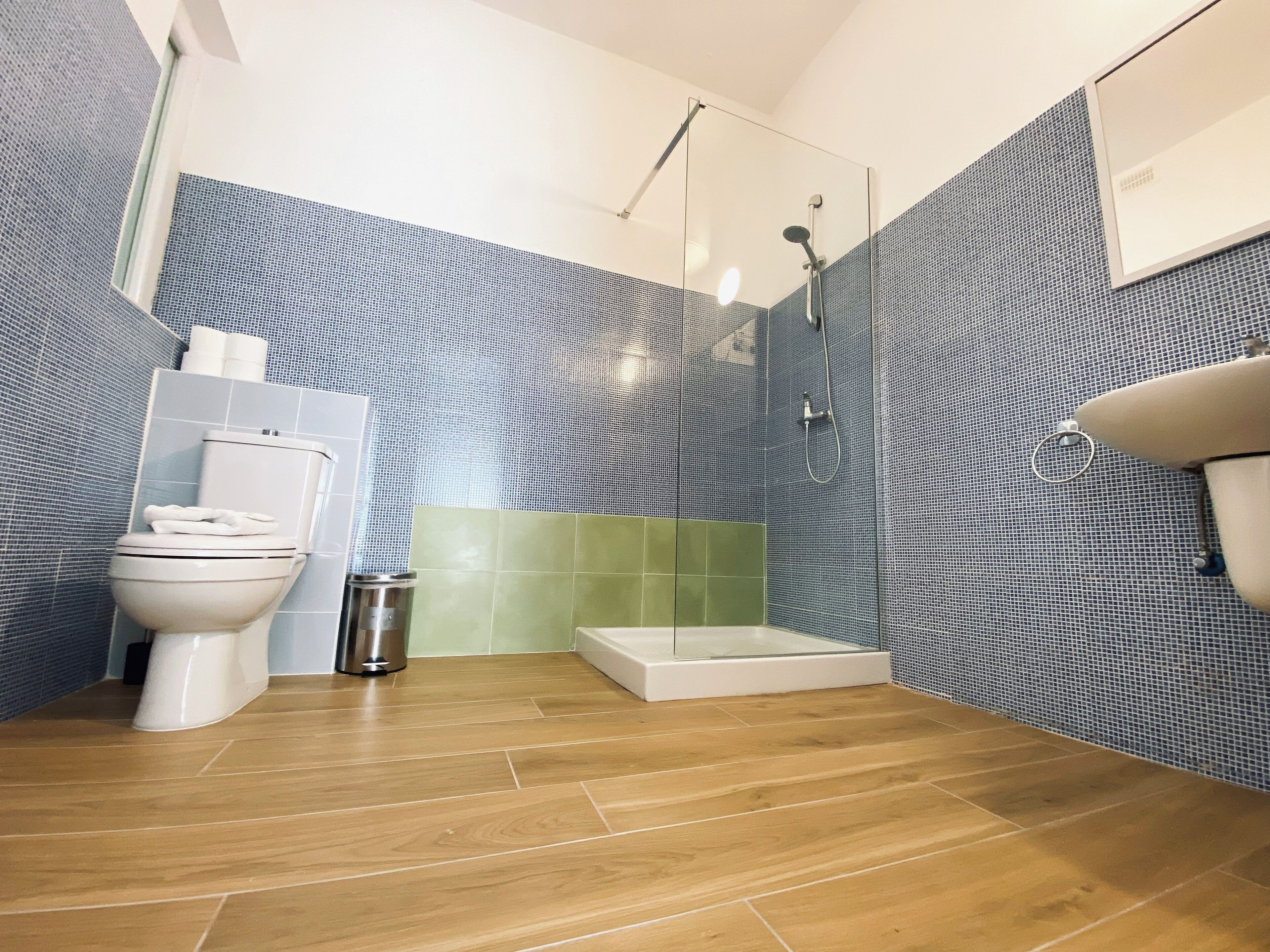 A modern bathroom with a toilet, shower, and sink.