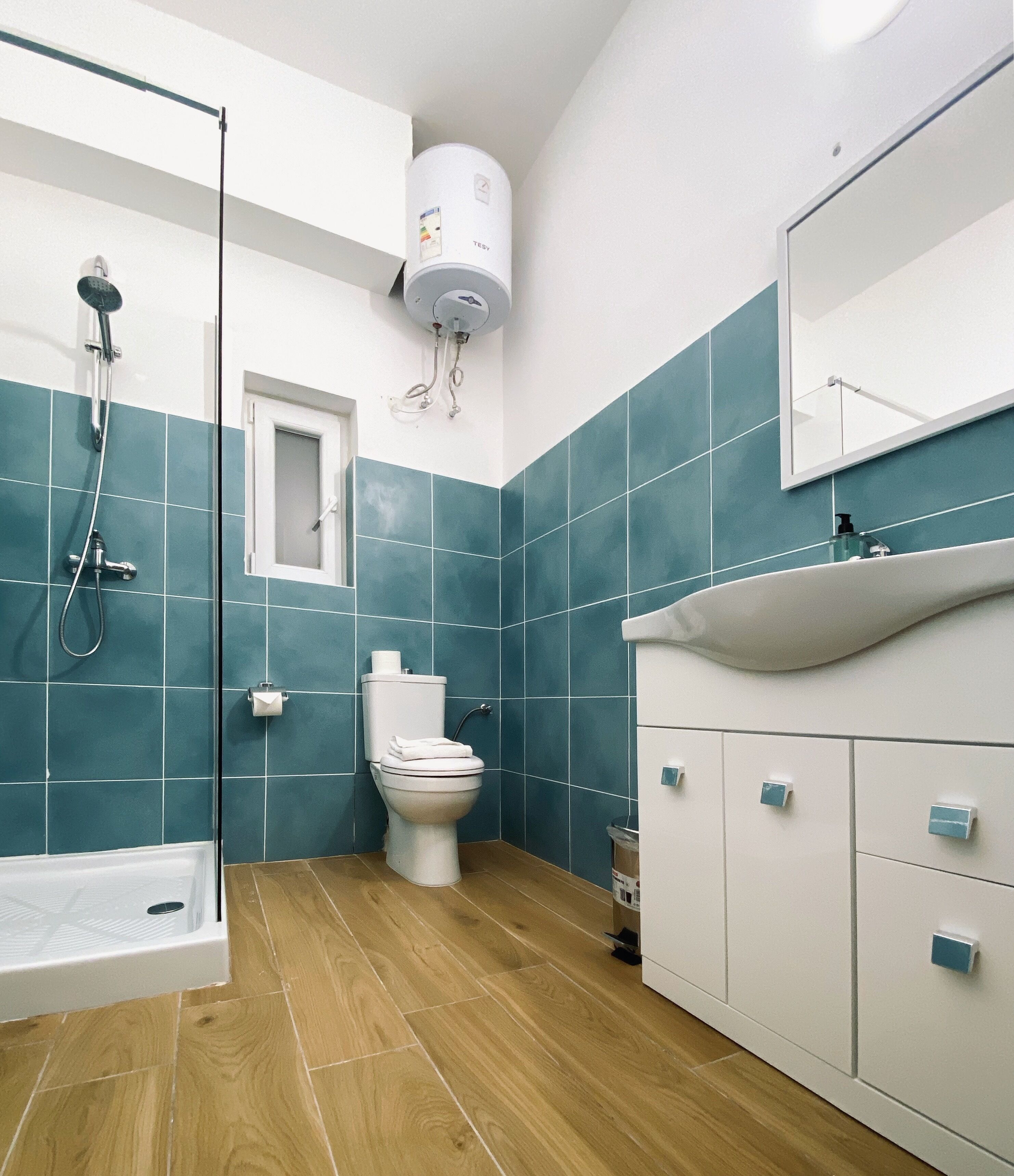A modern bathroom with a shower, toilet, and sink.