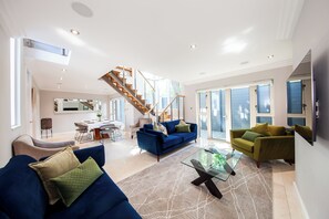 A spacious living room with a staircase, a dining area, and a large window. - Dublin Retreat Sleeps 6 With Parking (Dublin)