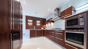 Una cocina moderna con electrodomésticos integrados, muebles de madera y un piso de baldosas impecable.
