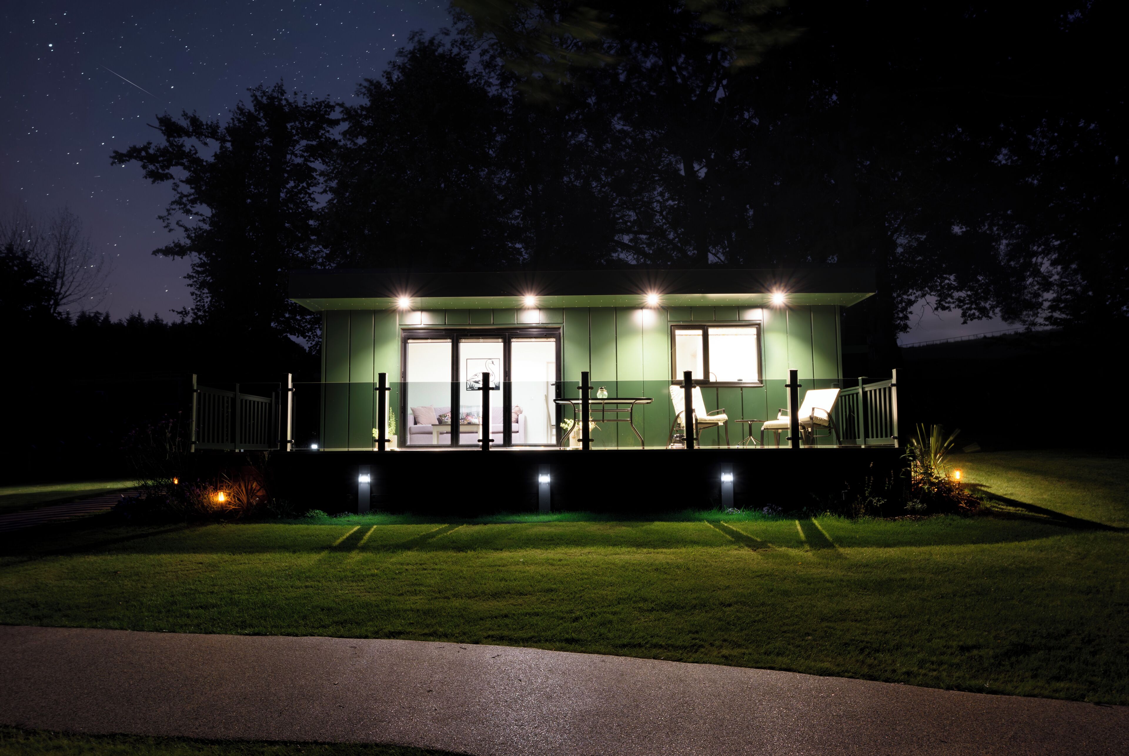 A small, single-story building with a green exterior and a covered outdoor seating area.