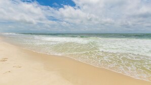 Une plage avec un ciel dégagé et des vagues.