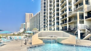 Une piscine dotée d’une architecture moderne, entourée d’un immeuble à étages avec des balcons.