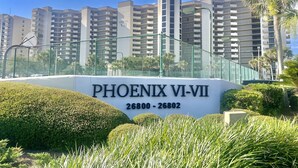 Une enseigne indiquant « PHOENIX VI-VII », avec les numéros d’appartements 26800 à 26802, entourée de verdure et avec de grands immeubles d’habitation en arrière-plan.
