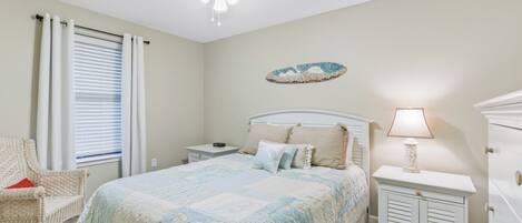 A bedroom with a bed, nightstand, dresser, and a ceiling fan.
