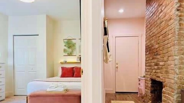 A bedroom with a bed, a dresser, a mirror, and a fireplace. - Mins to Stadiums & Steps to Northside and AGH (Pittsburgh)